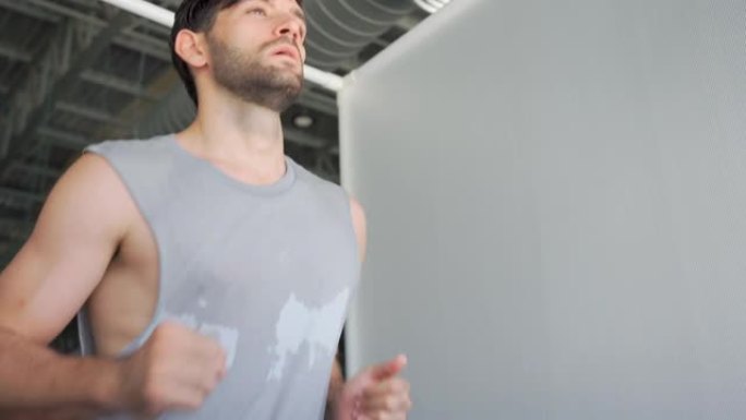 男子在运动健身房的跑步机上锻炼和跑步。