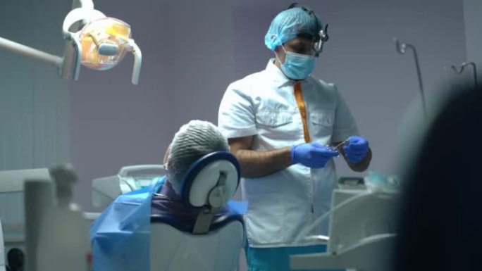 从自信的中东牙医准备麻醉注射到辅助医疗工具慢动作的支架重点。专业医生和护士在医院准备治疗。