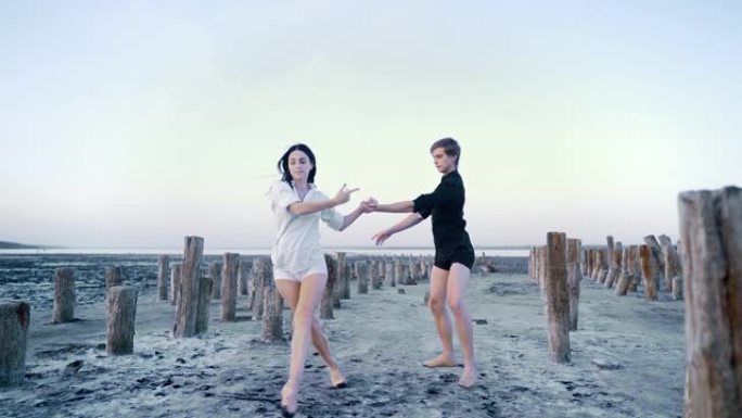 情侣在沙滩上表演的专业情感芭蕾舞演员。古典或现代芭蕾优美的感性元素。慢动作。