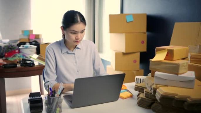小型企业主在家庭办公室使用计算机检查订单交付。