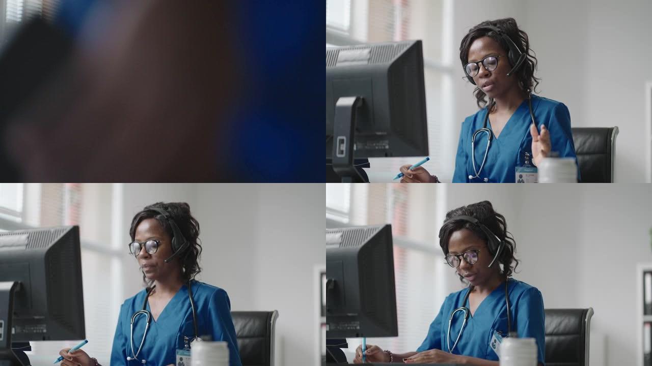 一名戴着耳机的黑人女医生坐在电脑桌旁，接听患者的电话，查看他们的病历并将其输入到诊所时间表中。
