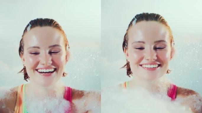 快乐美丽的女人快乐而轻松地覆盖着沐浴泡沫。慢动作，垂直拍摄。