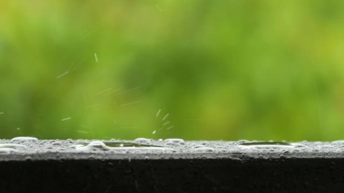 慢动作雨滴在大雨时滴落。雨天和雨水在大自然中下降。平静放松的冥想平静的背景。雨滴滴在露台阳台的木栏杆