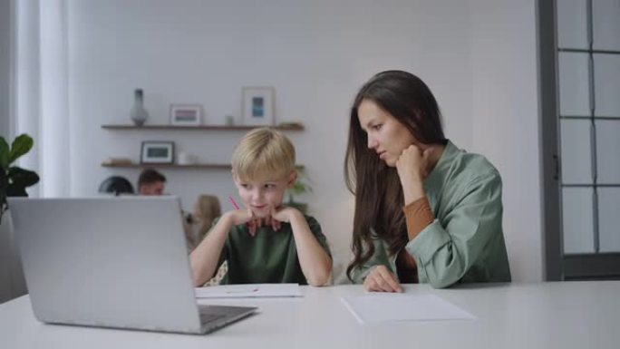 妈妈和儿子正在看笔记本电脑屏幕，分析远程学习的课程。学习外语