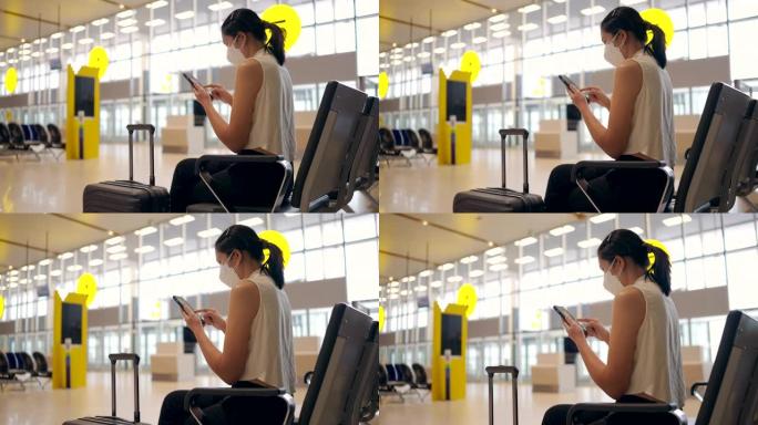 亚洲妇女在机场出发区使用数字平板电脑戴口罩。