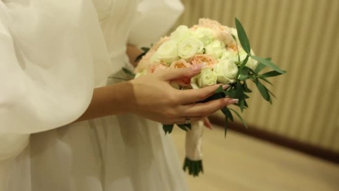 穿着婚纱的新娘捧着一束美丽的鲜花