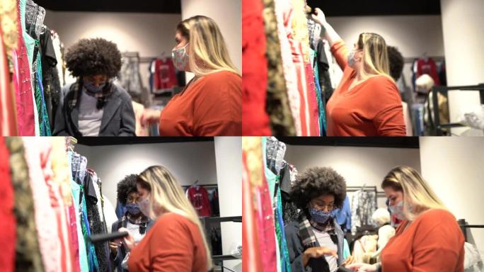 戴着口罩的年轻女子在旧货店购物时受到女售货员的帮助