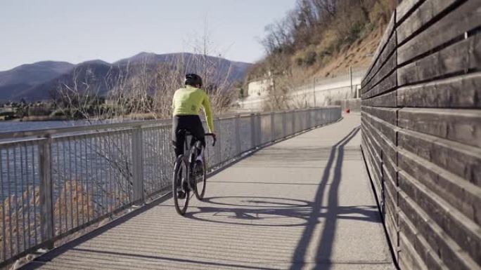 公路自行车手在湖边的自行车道上经过