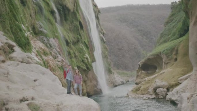 徒步旅行时探索河流和瀑布的年轻男女