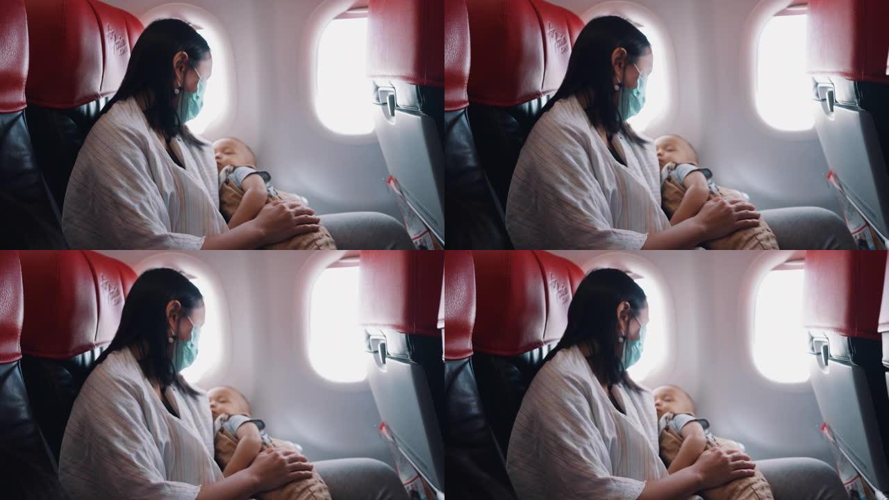 小男孩乘飞机旅行时睡在妈妈怀里