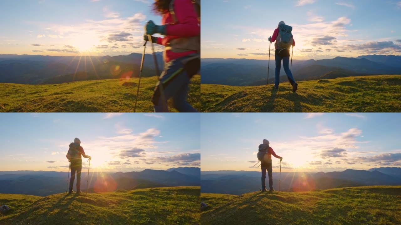 女徒步旅行者在日落时到达山顶