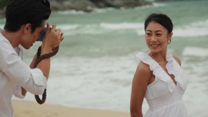 男子用相机捕捉与女友在海滩上的浪漫回忆