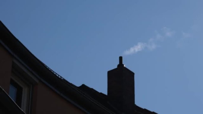 在湛蓝的天空中冒烟的烟囱