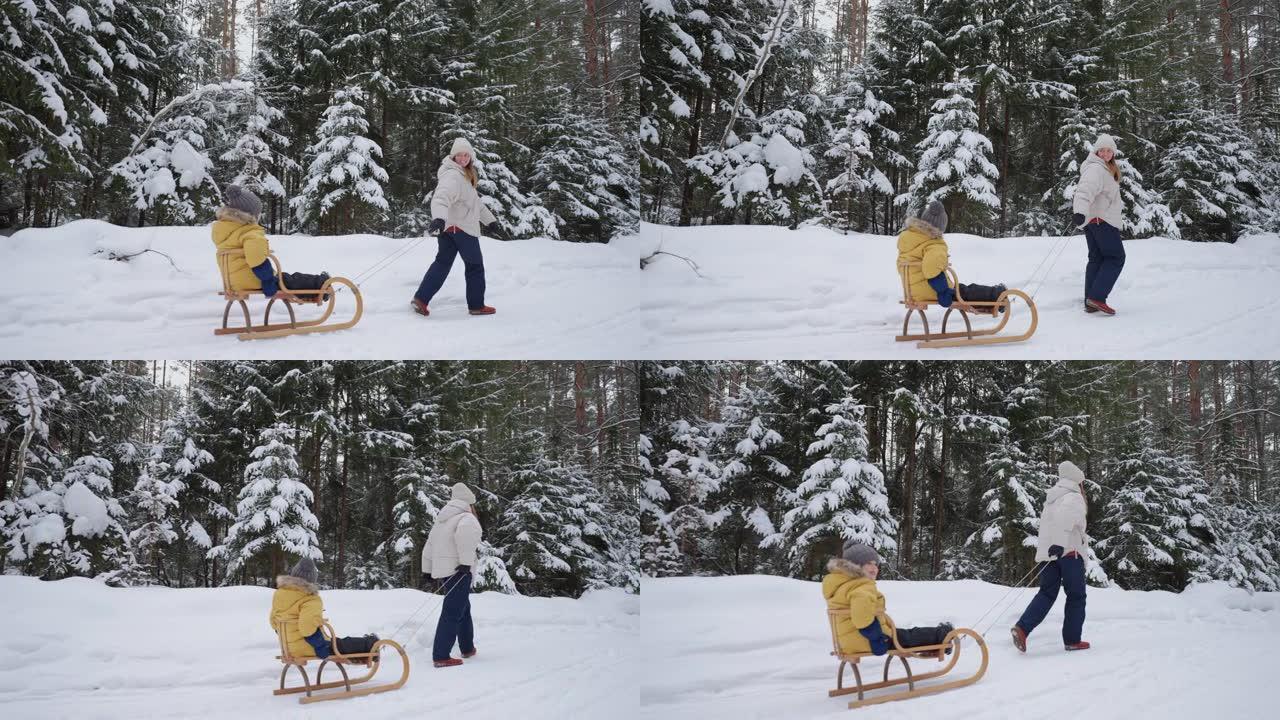 快乐的女人和她的小儿子在森林里玩得开心，母亲带着孩子拉雪橇
