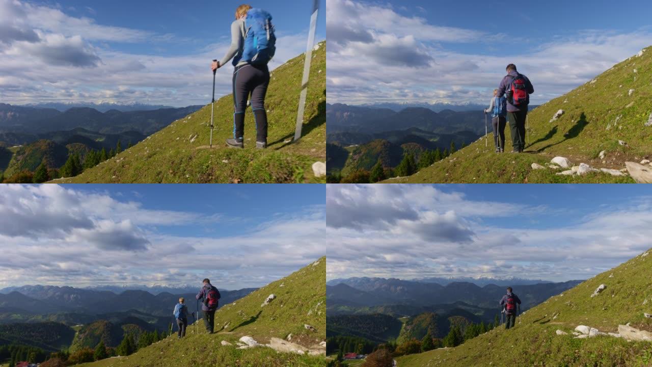 一个高级男人和一个女人在阳光下的风景优美的小径上下山