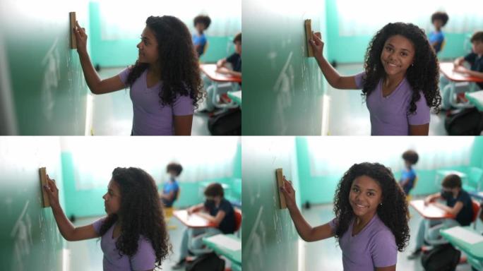 一个女孩在教室里擦黑板的肖像