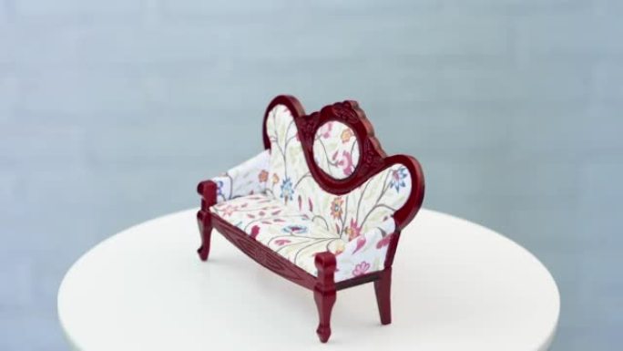 用于娃娃屋装饰的令人惊叹的老式沙发。旋转桌上可爱的微型家具。特写。