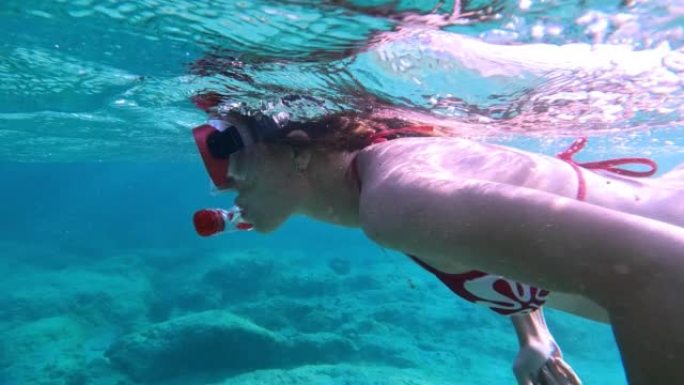 女人在海里浮潜。通过可穿戴相机游泳