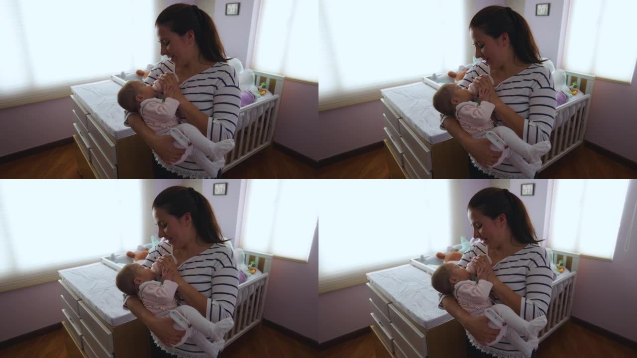 甜蜜快乐的母亲在托儿所喂养一个5个月大的女婴，她戴着髋关节发育不良支架