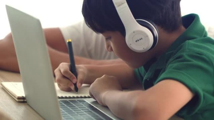 可爱的男孩专注于在家笔记本电脑上在线学习。