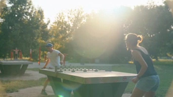 夏天晚上，男人和女人在公园打乒乓球