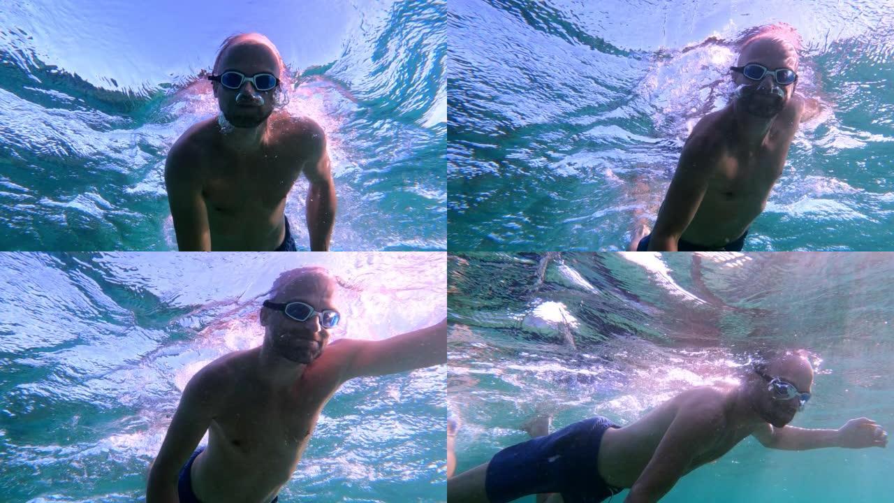 夏天在海里浮潜。男子游泳和跳入水中。水下射击