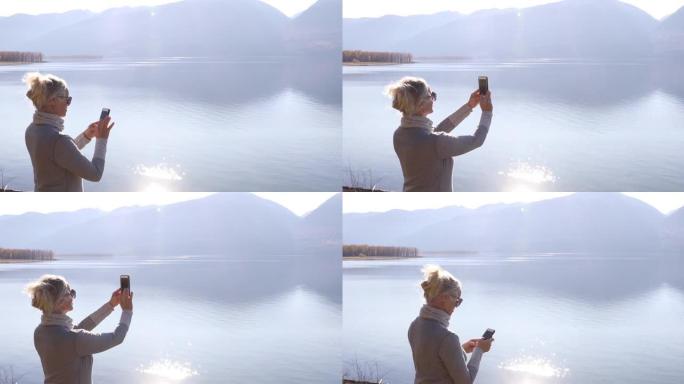 女人拍山湖的智能手机照片