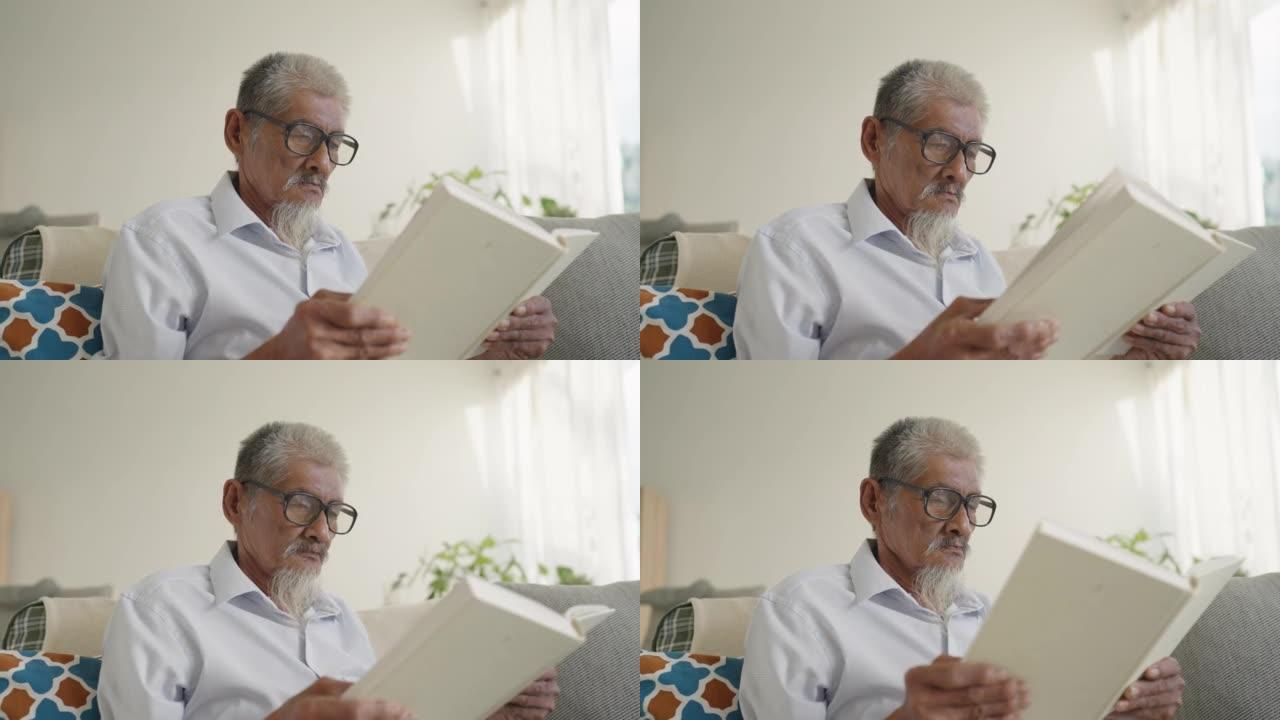 亚洲资深老人白发老人在家坐在沙发上看书