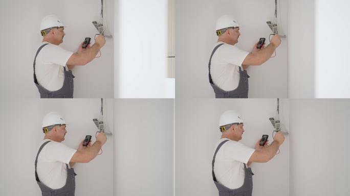 一名男电工检查变压器的工作，以照亮公寓中的低压网络