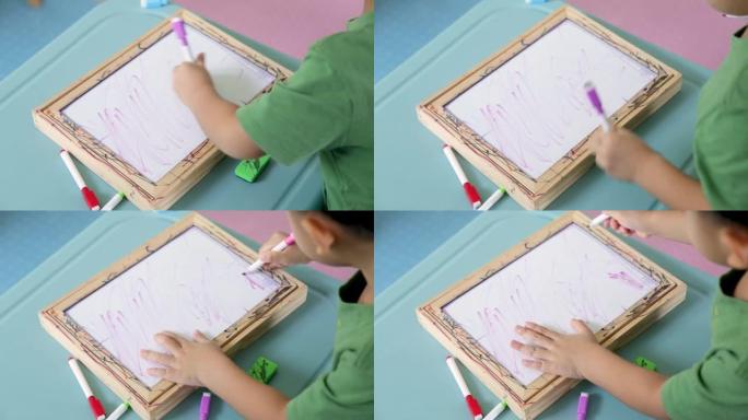 亚洲男孩在黑板上写台词，在家学习。
