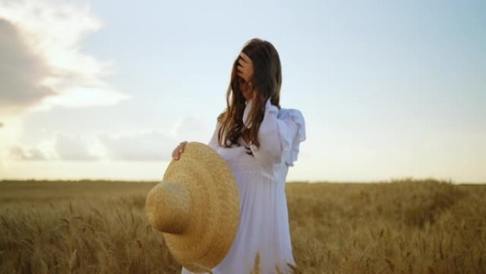 快乐无忧无虑的黑发女人在夏天或日落时分独自走在田野里