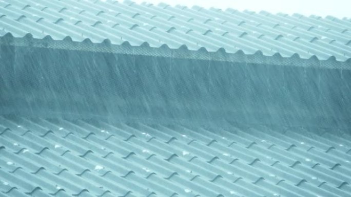 大雨倾泻在房屋的屋顶上。