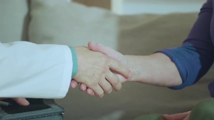 男医生对一名老年女性患者进行诊断并在离开前握手