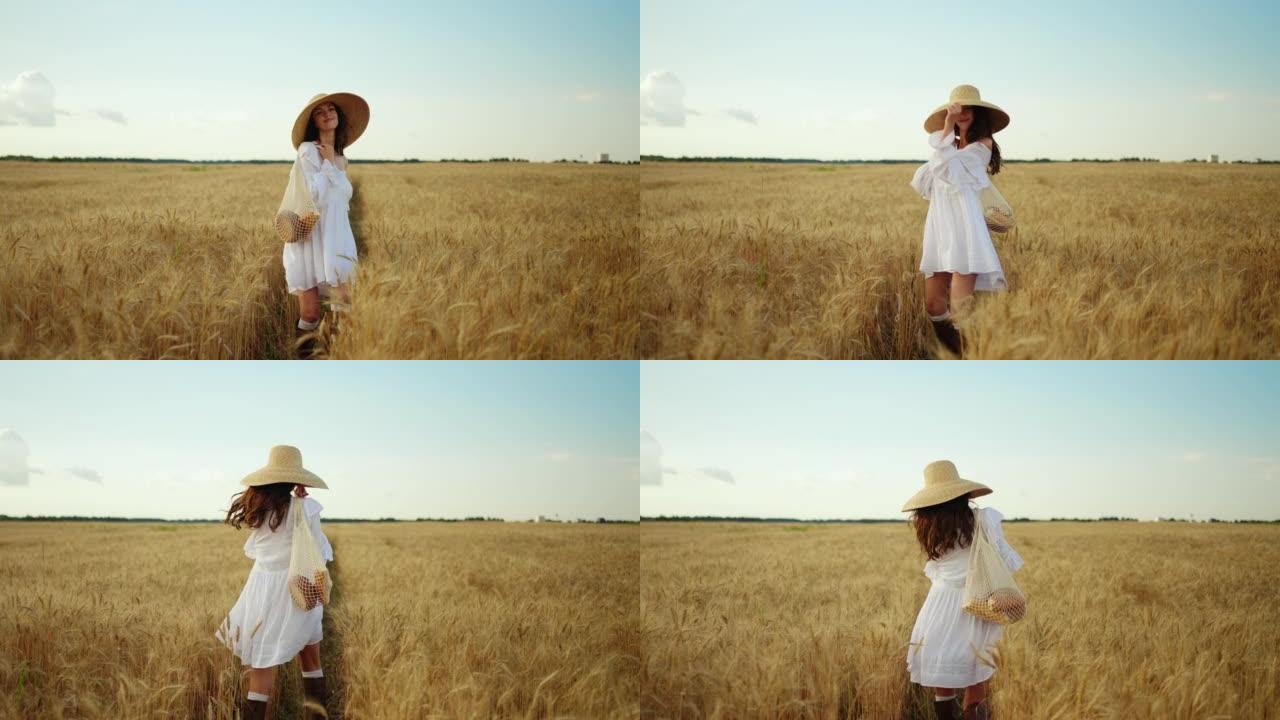 夏日无忧无虑的漂亮女人走在成熟的麦田上，穿着白色连衣裙的女士微笑着