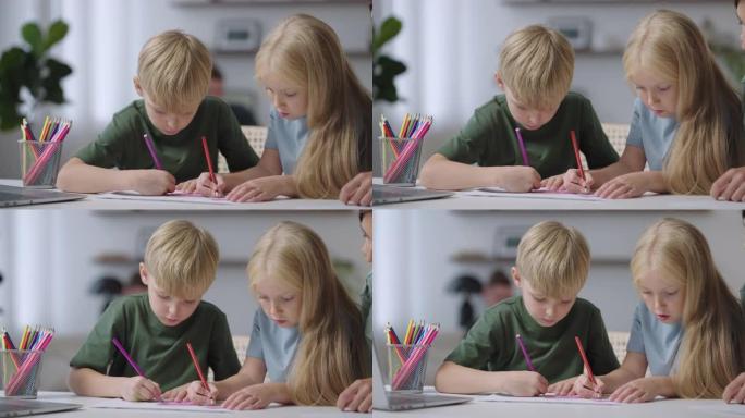 两个孩子坐在桌子旁画画，妈妈帮忙。一个男孩和一个女孩在桌子上画画
