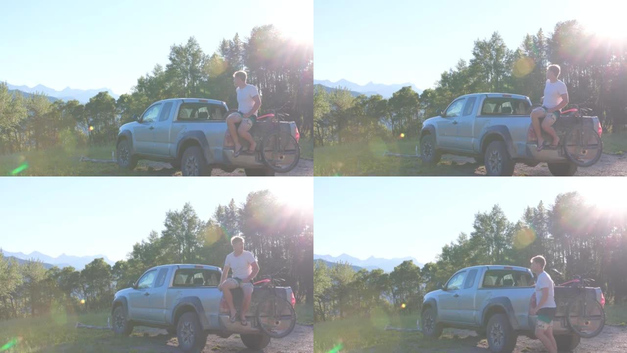 骑自行车后，男子停在卡车的后挡板上