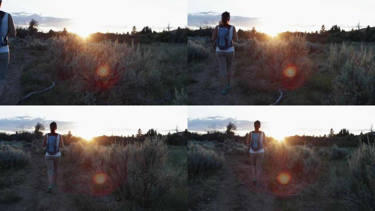 日落时在锡安国家公园徒步旅行的女人