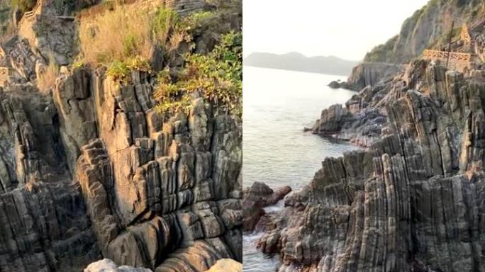 岩石海岸线向日落平移的垂直镜头