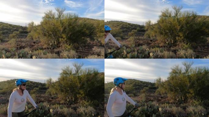 沿着沙漠小径骑自行车的女人的第一人称视角