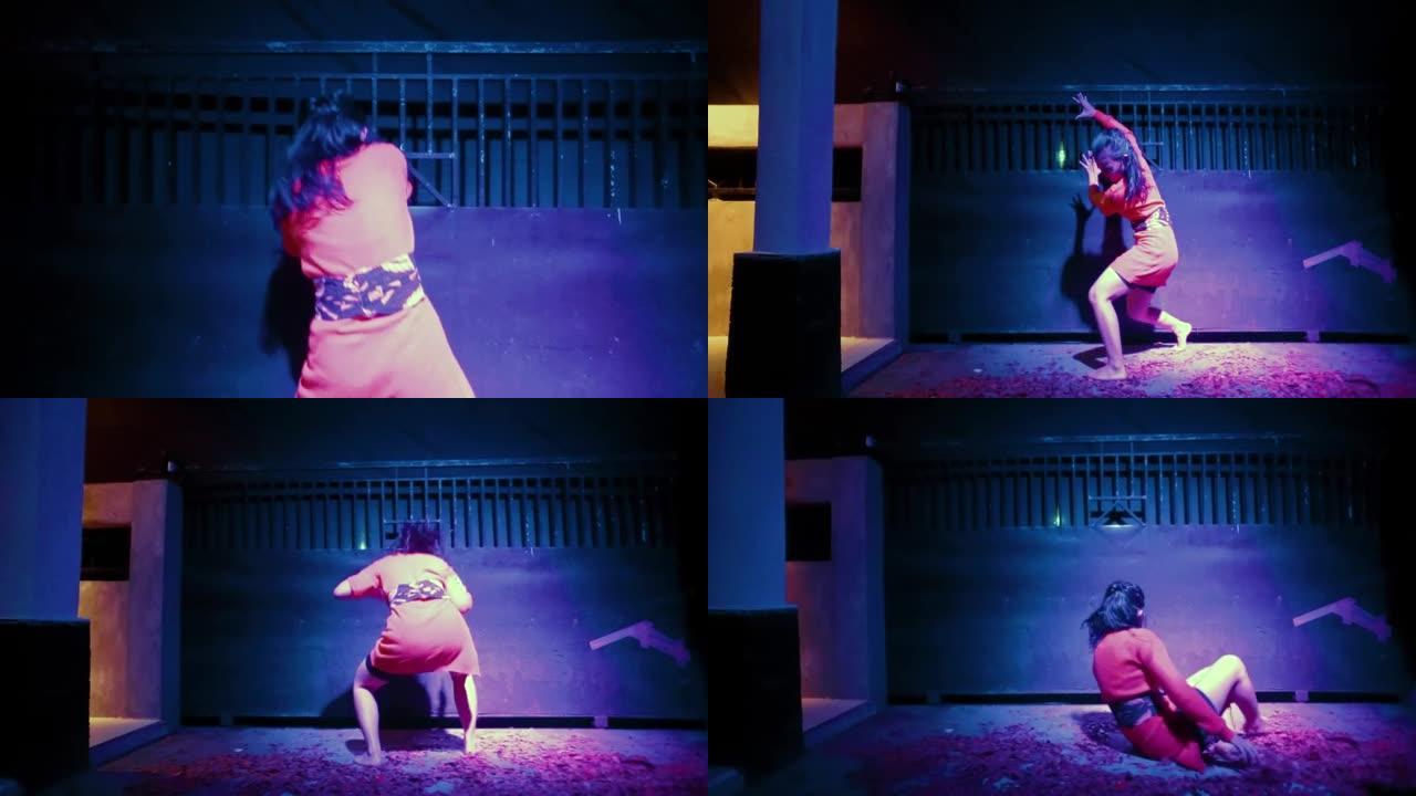 伤心欲绝的亚洲女性在紫色灯光下的黑色篱笆前跳舞