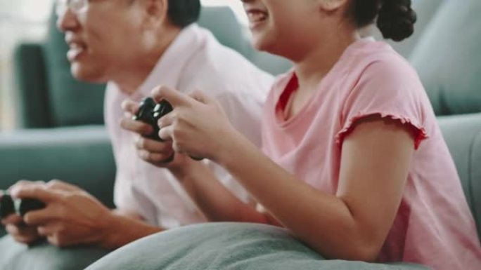 父亲和女儿一起在家玩电子游戏