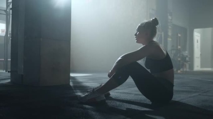 职业女运动员在训练后在健身房的地板上哭泣，创伤或失败，筋疲力尽的女人