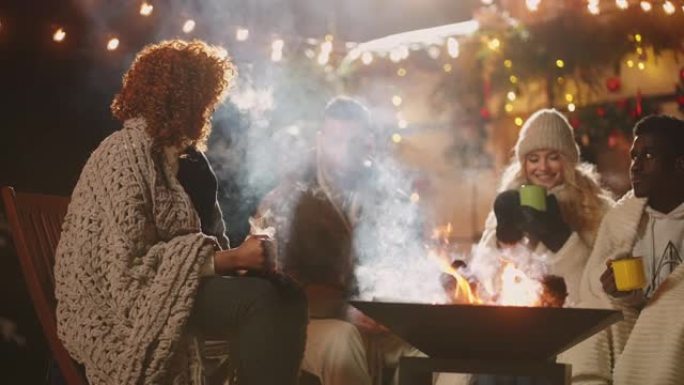 黑人和白人在大自然中一起庆祝圣诞节，男人和女人围坐在火旁