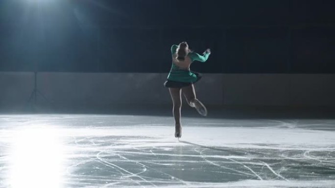 初级女花样滑冰运动员独自在溜冰场表演，年轻的运动女孩正在旋转，慢动作射击
