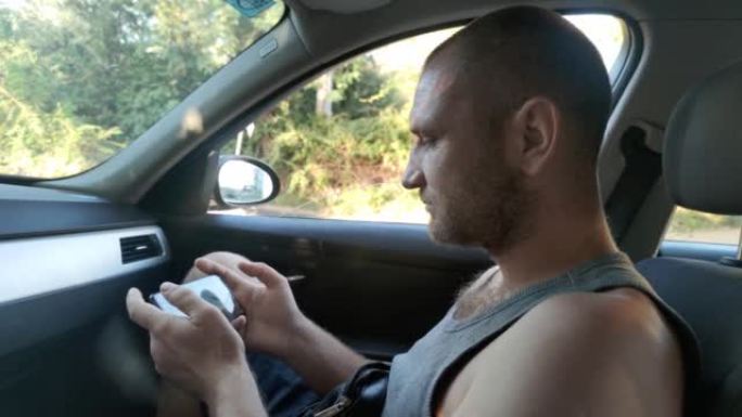 一个人的手拿着手机，车里的人正在玩智能手机。