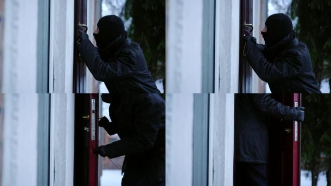 侧视图小偷撬锁在冬天进入空房子。戴着滑雪面具的白人年轻人在私人财产中折断。违法行为和违法行为。