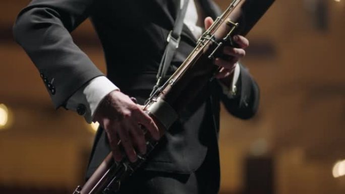 才华横溢的bassoonist在歌剧院的音乐会上演奏音乐，现场有bassoon的音乐家