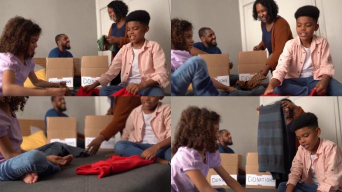 带孩子的父母整理衣服放在盒子里在家中捐赠
