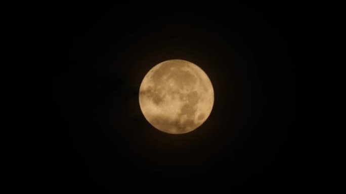 夜间乌云在超级月亮上空移动的4k实时镜头。