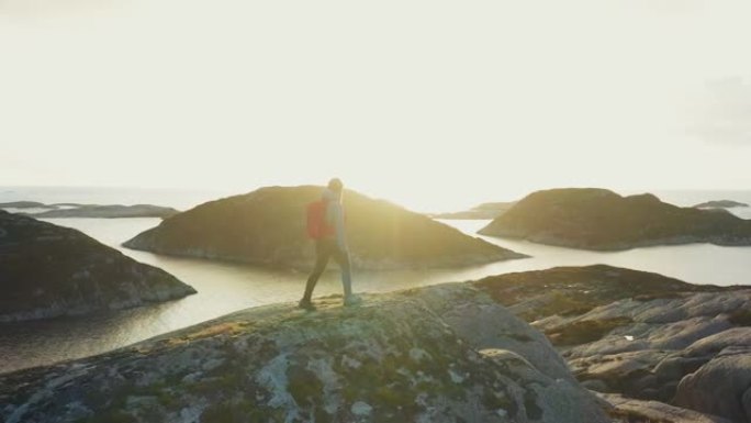 在挪威进行户外徒步旅行: 峡湾旁一名妇女在山上的无人机景观